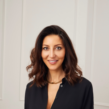 A portrait of Nadine Merabi wearing black suit