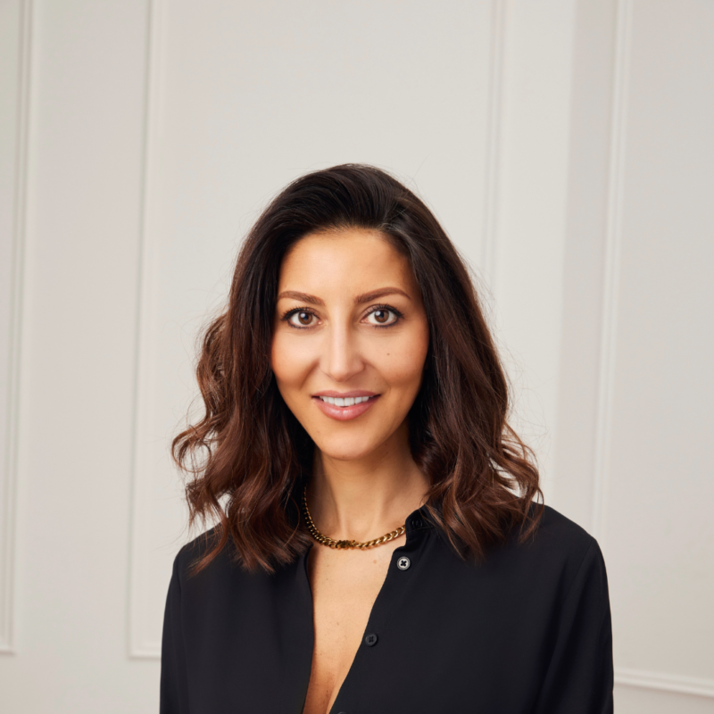 A portrait of Nadine Merabi wearing black suit