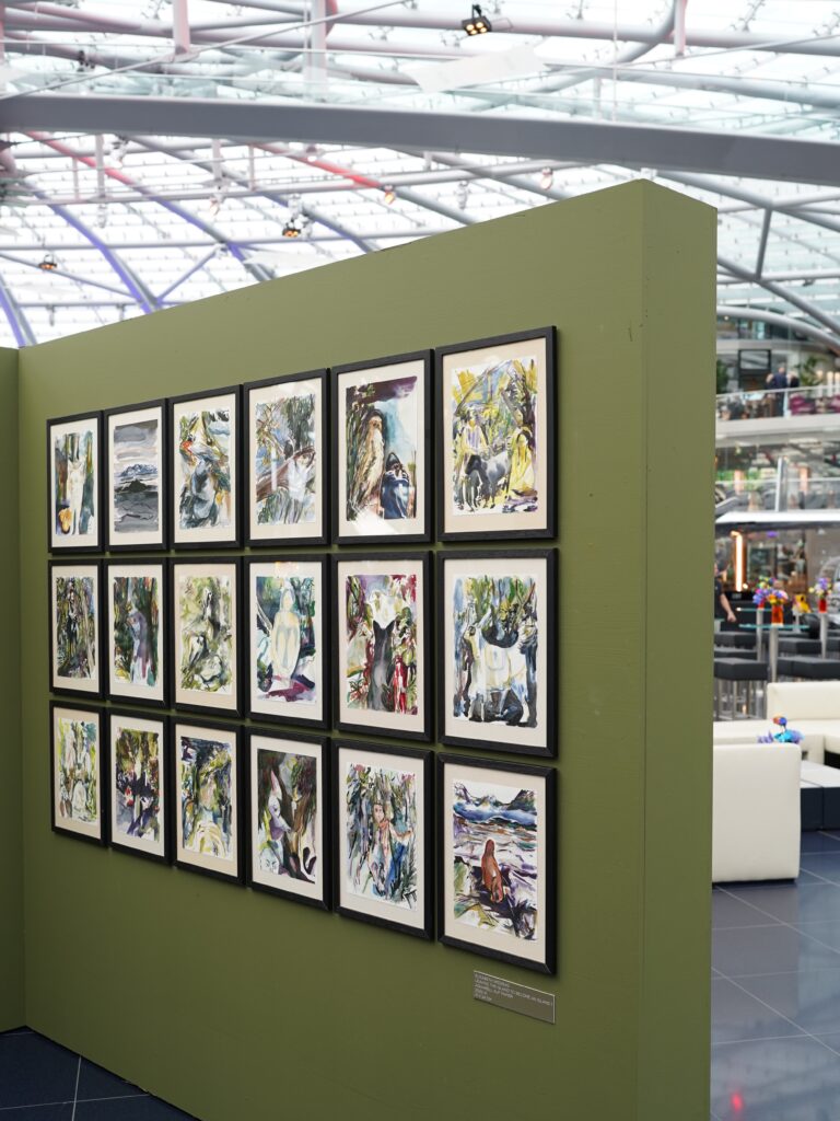 A green wall with art frames at Hangar 7