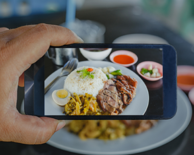 Food Photography: A man using a smartphone to take a picture of rice dished in white ceramic
