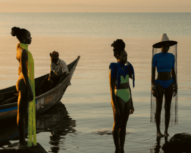 Three Women wearing Epica Jewellery and staying at the bank of a river with a man in a canoe sailing at the background