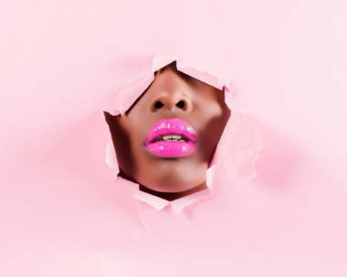 A female face in a pink cut out cardboard