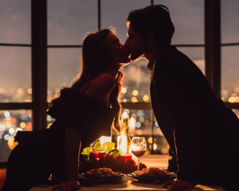 Detailed view of a homemade Valentine's dinner table for two, featuring a delicious meal, champagne flutes, and valentine-themed decorations
