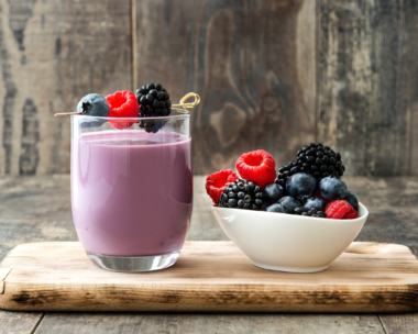 A colorful array of spring smoothie recipes made with fresh fruits and vegetables on a bright kitchen counter.