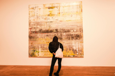 A lady standing in front of an Abstract art in a living space
