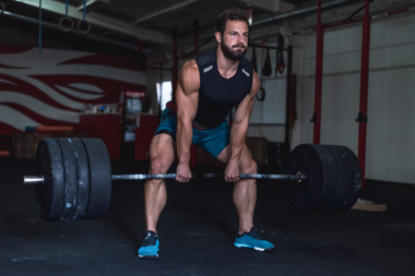 A muscular man lifting weights in a gym highlighting potential red flags in frequent male gym-goers