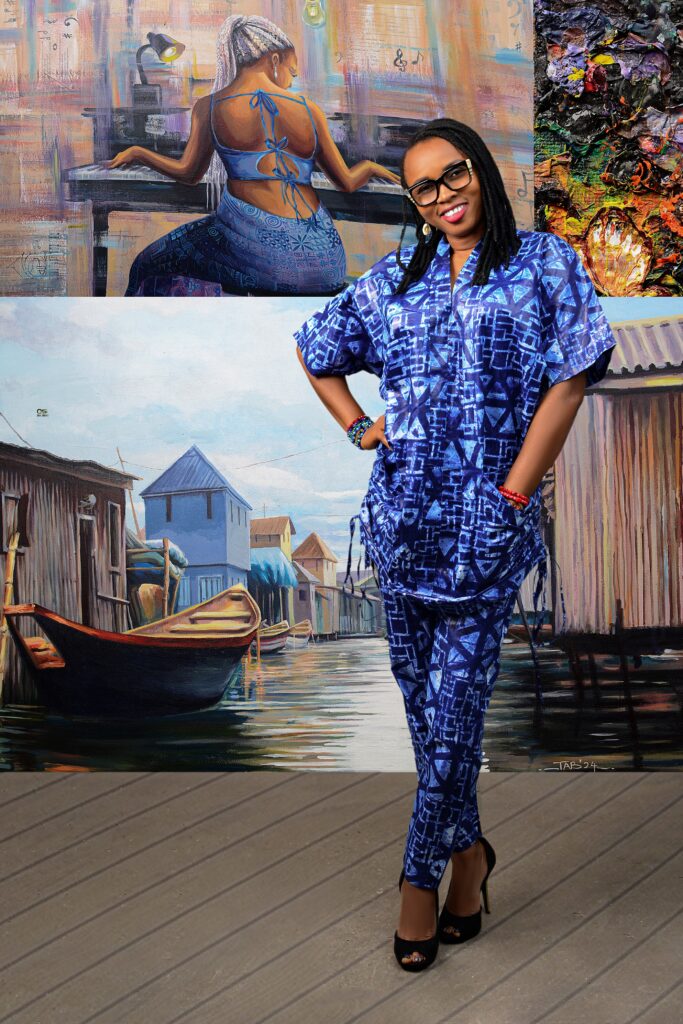 Tabitha Odigili in front of her art painting in a studio
