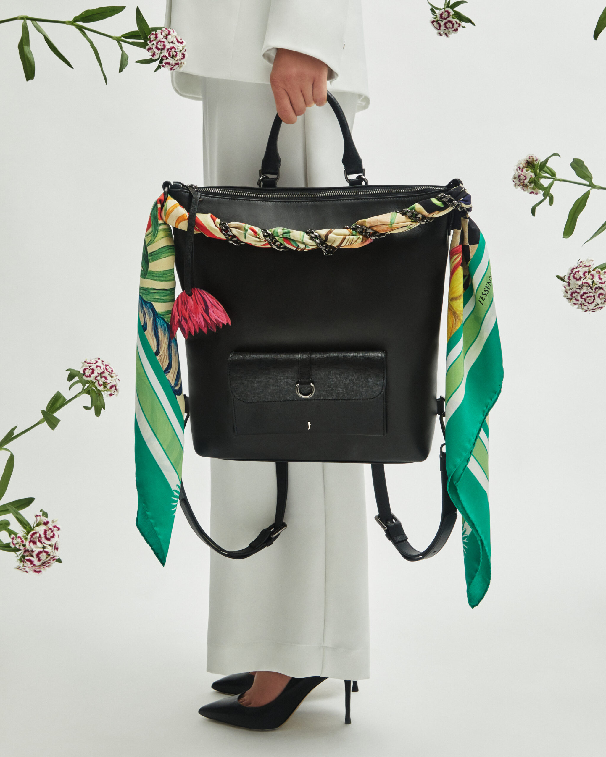 A vibrant leather bag from J'ESSENTIA's PrimavERA collection featuring geometric shapes and lotus charm details.