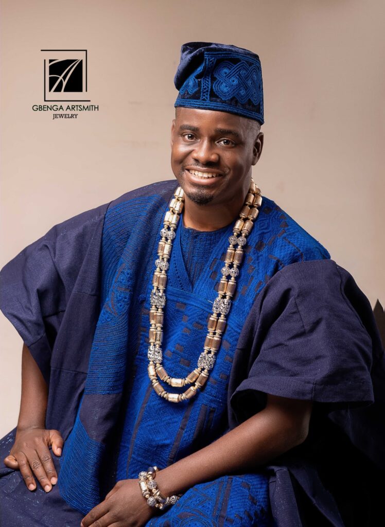 Gbenga Artsmith wearing his signature accessory designs while showcasing a fashion-forward outfit from his new collection