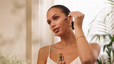 Bottle of Rituals Cosmetics self-tanning face drops placed beside moisturizer and sunlight, symbolizing summer glow skincare.