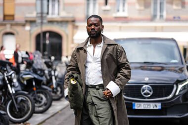 Adekunle Gold performing at an Afrobeats concert, representing quiet wealth and success.