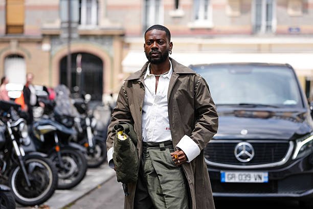 Adekunle Gold performing at an Afrobeats concert, representing quiet wealth and success.