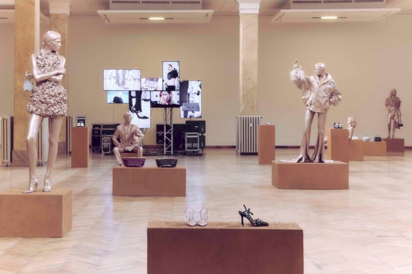 Golden life-sized figures at the Jimmy Choo Spring 2027 presentation during Milan Fashion Week